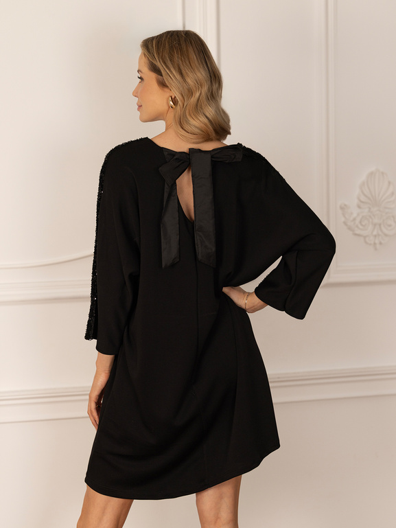 Czarna sukienka z cekinami na ramionach i kokardą na plecach