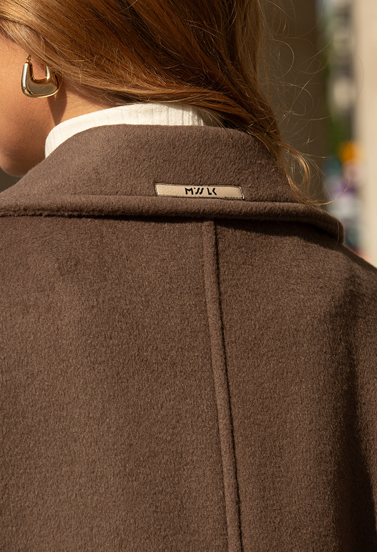 Beżowy szeroki płaszcz z pikowanym kołnierzem i rękawem